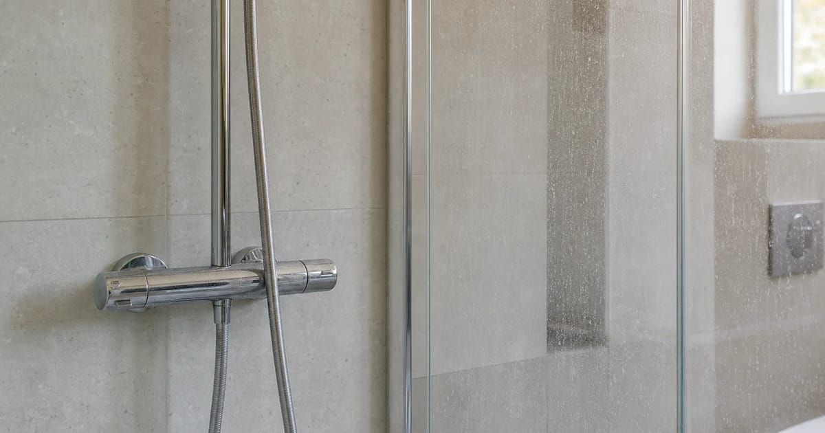 Dusche mit Wasserflecken auf Glas und Armatur