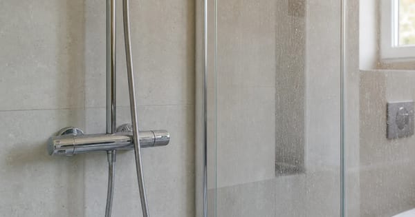 Dusche mit Wasserflecken auf Glas und Armatur